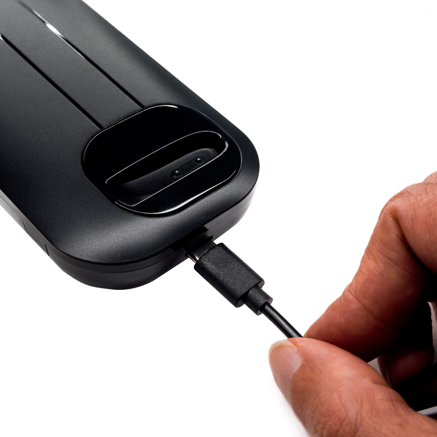 Hand connecting a charging cable to the Black & Gray headset case