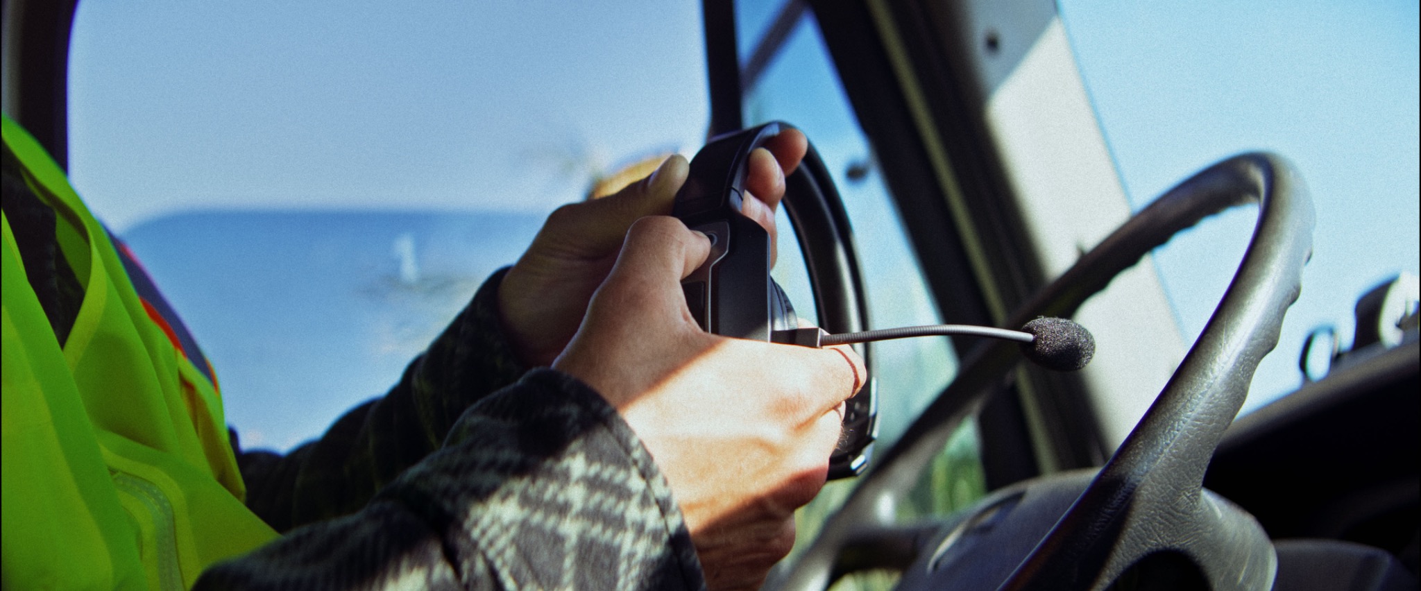 Close view of a driver holding the Black & Gray headset