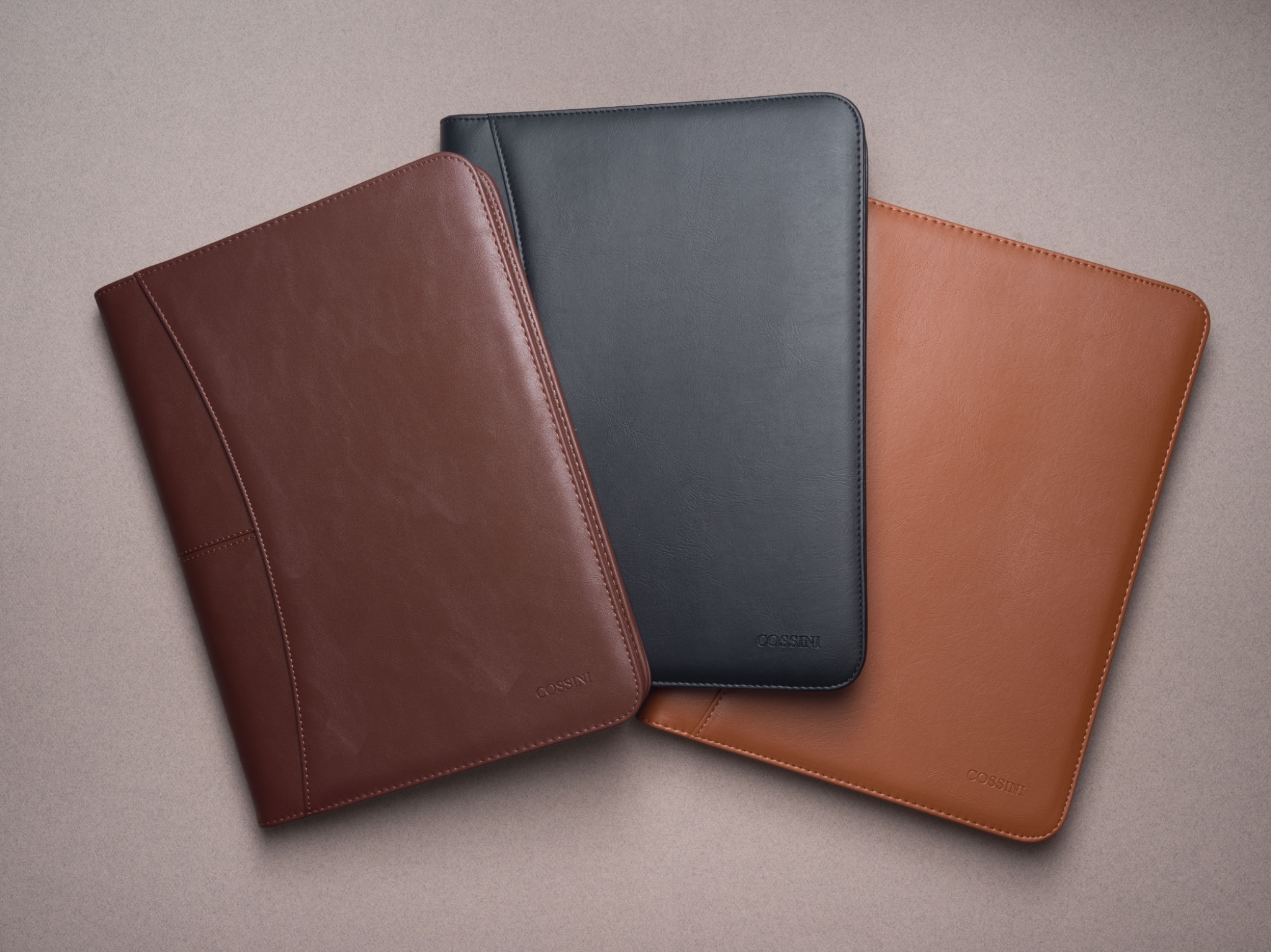 Three Cossini leather products arranged as a coordinated collection