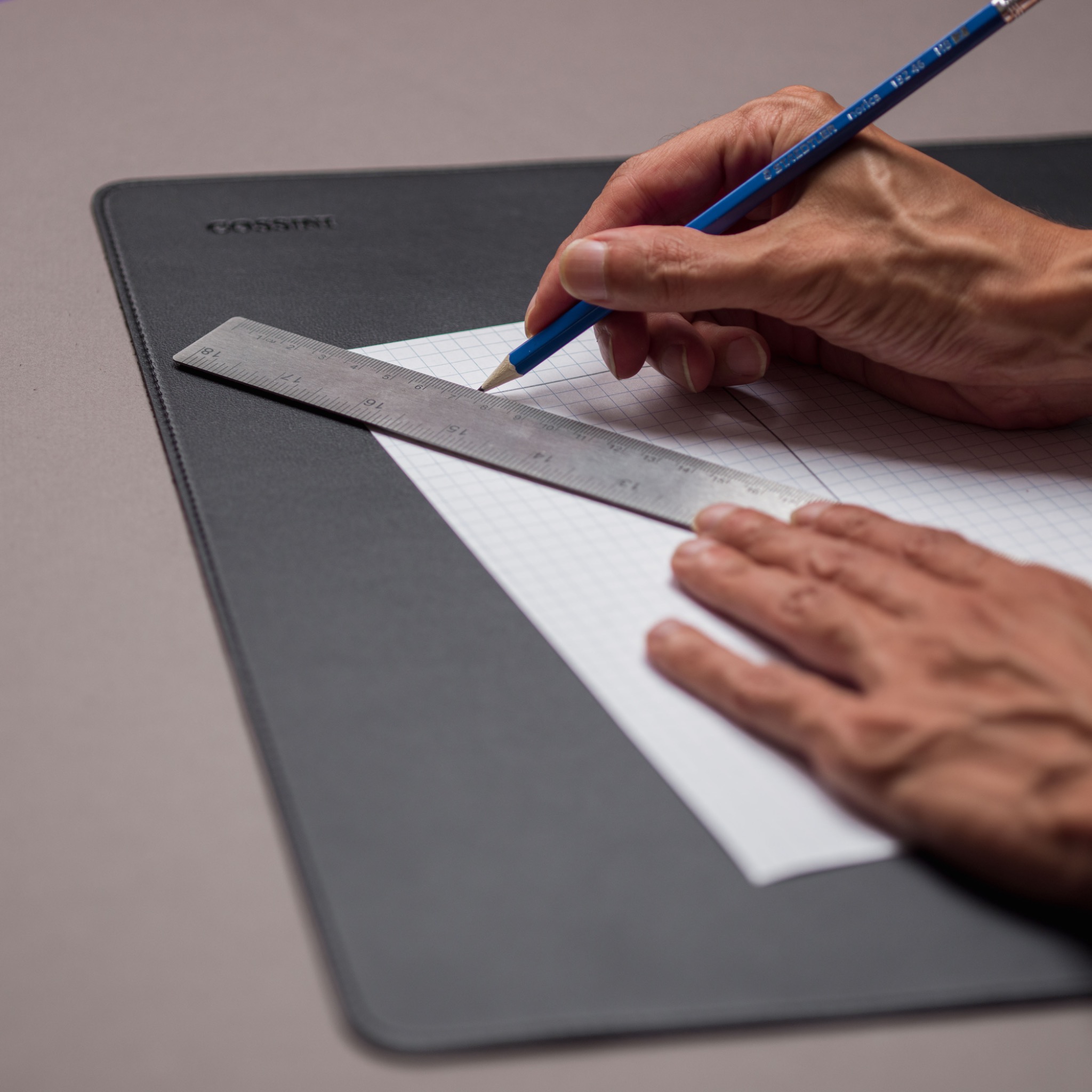 Hand interacting with a Cossini leather padfolio